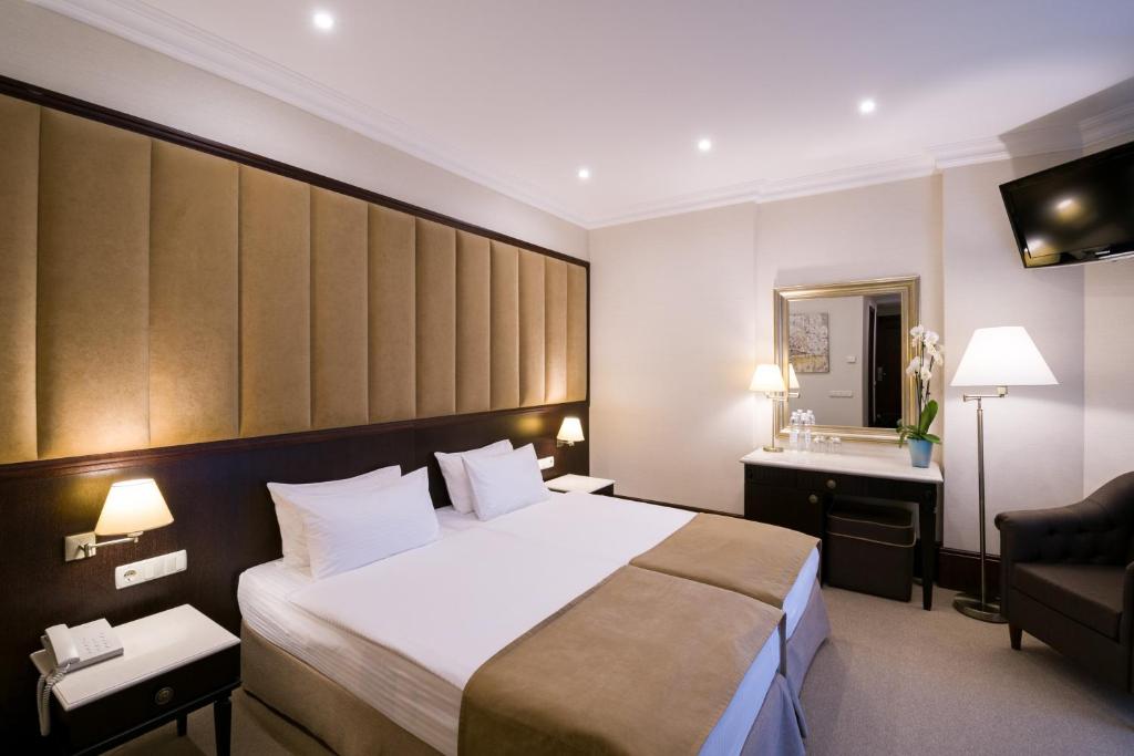 a hotel room with a large bed and a sink at Rixos-Prykarpattya Resort in Truskavets