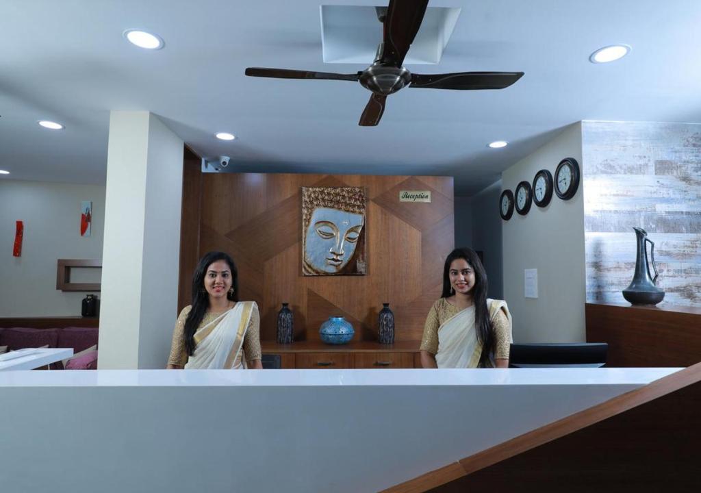 two women standing in front of a mirror at Swades Myhome in Trivandrum
