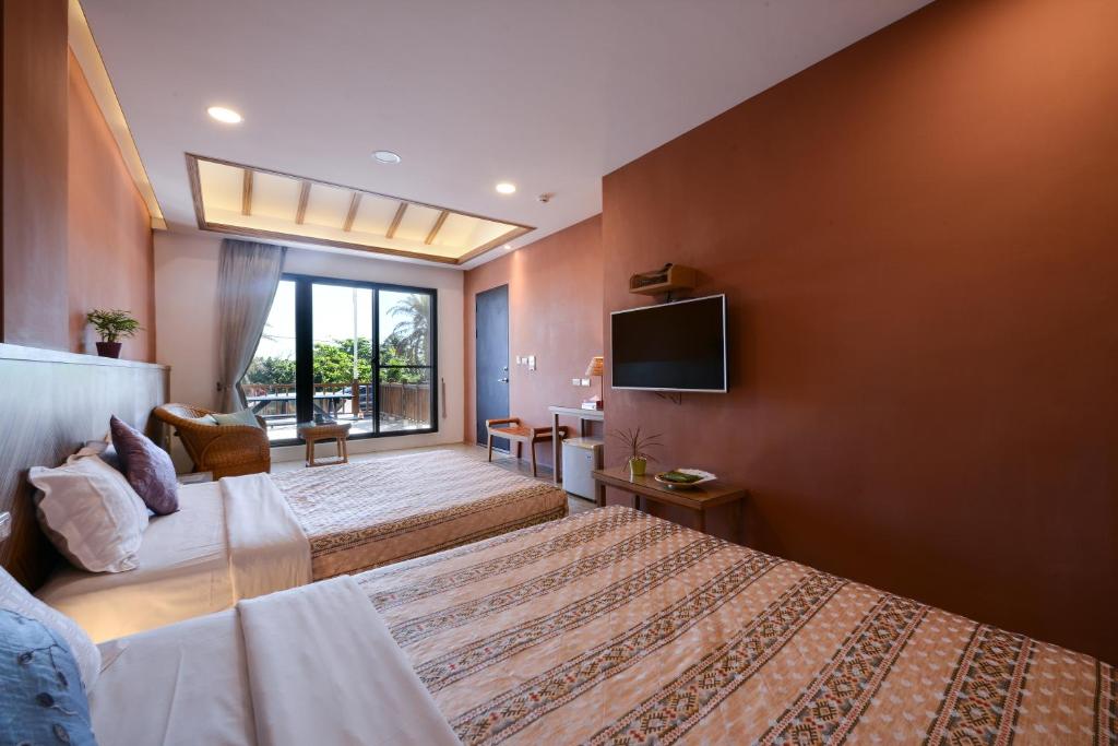 a hotel room with a bed and a tv at Kenting Coast Resort in Kenting