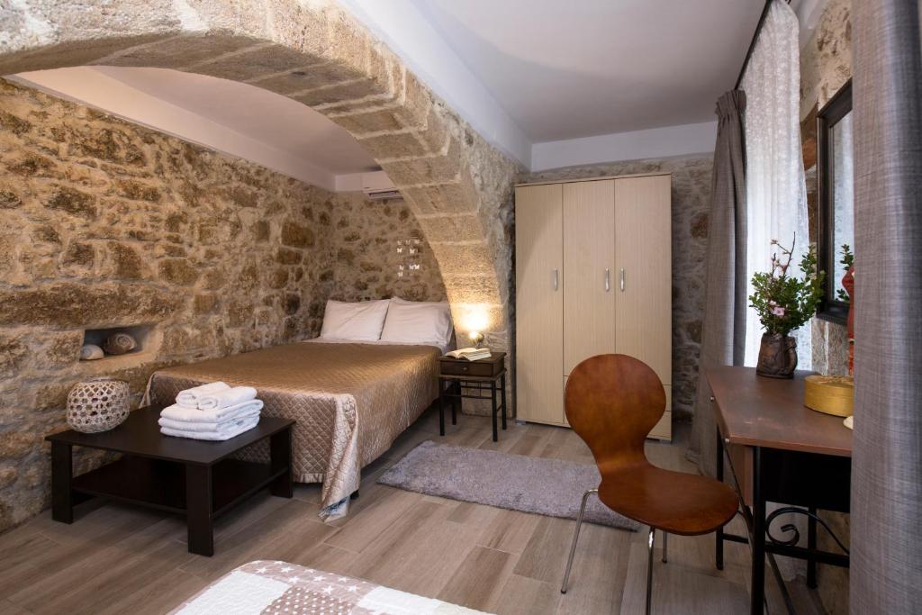 a bedroom with a bed and a table and a chair at Μylos in Kissamos