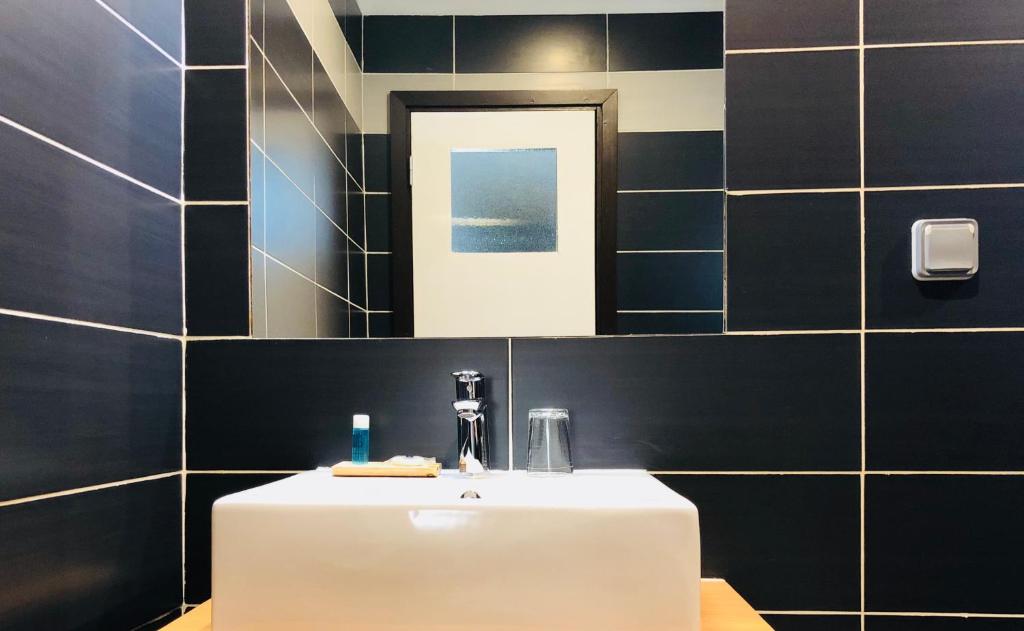 y baño con lavabo blanco y espejo. en Détente Hôtel en Abiyán