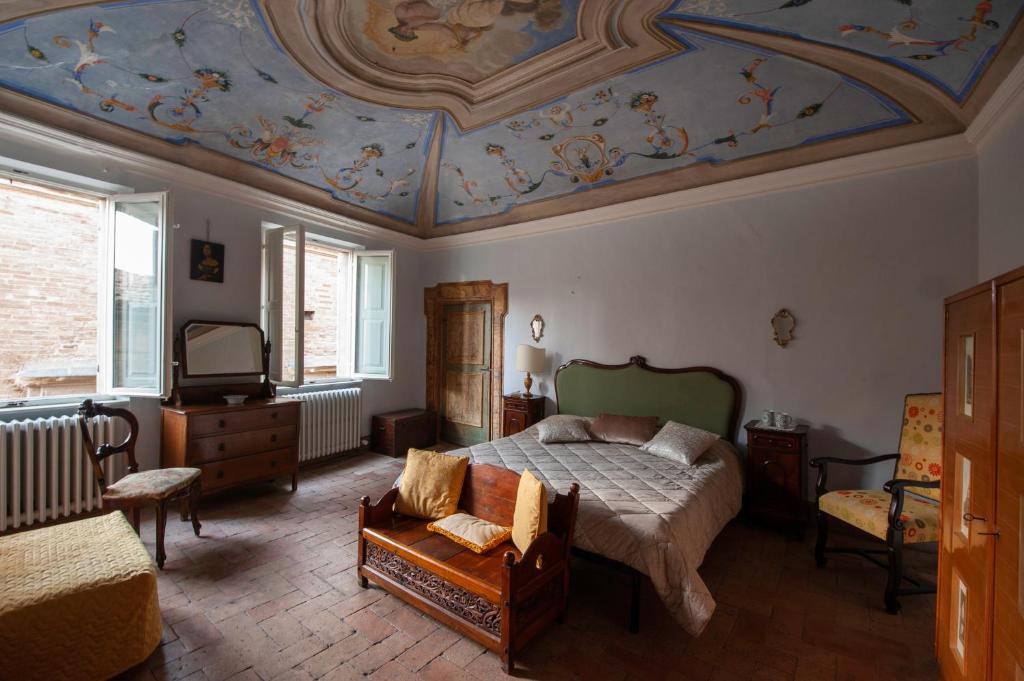 1 dormitorio con 1 cama y una pintura en el techo en Residenza storica Volta della Morte en Urbino
