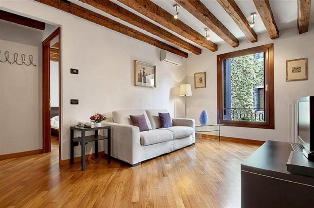 ein Wohnzimmer mit einem weißen Sofa und einem Tisch in der Unterkunft Salmaso Apartments in Venedig