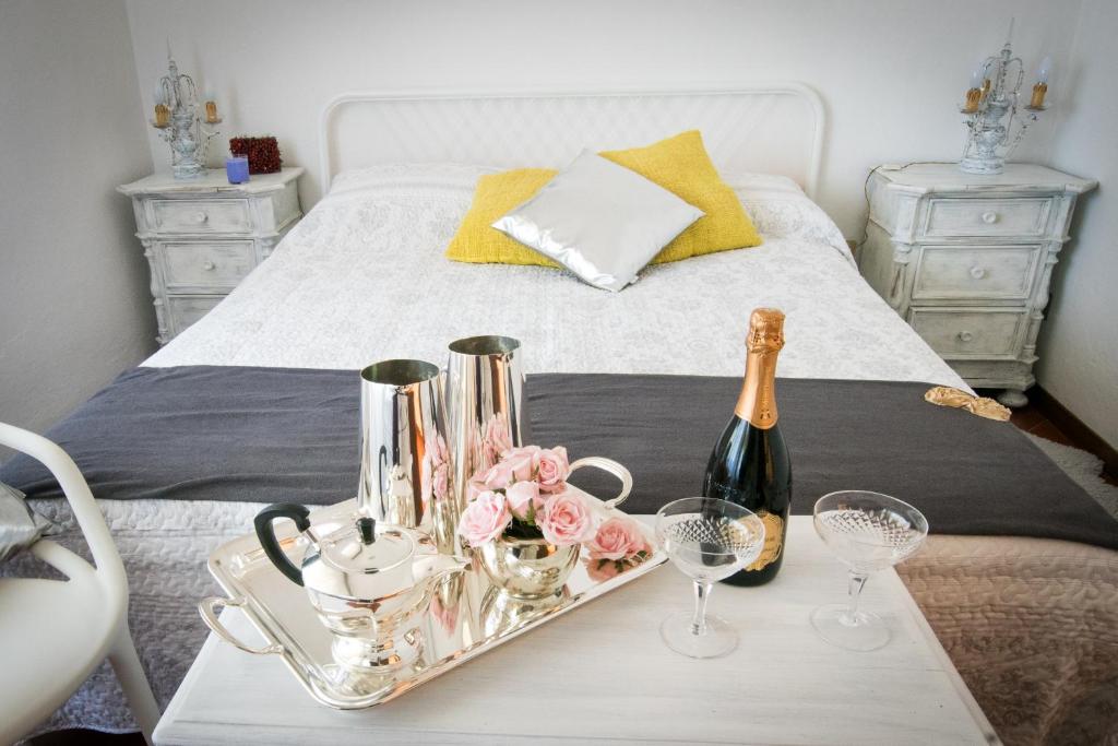 - un lit avec un plateau comprenant une bouteille de champagne et des fleurs dans l'établissement I Gelsomini, à Sienne