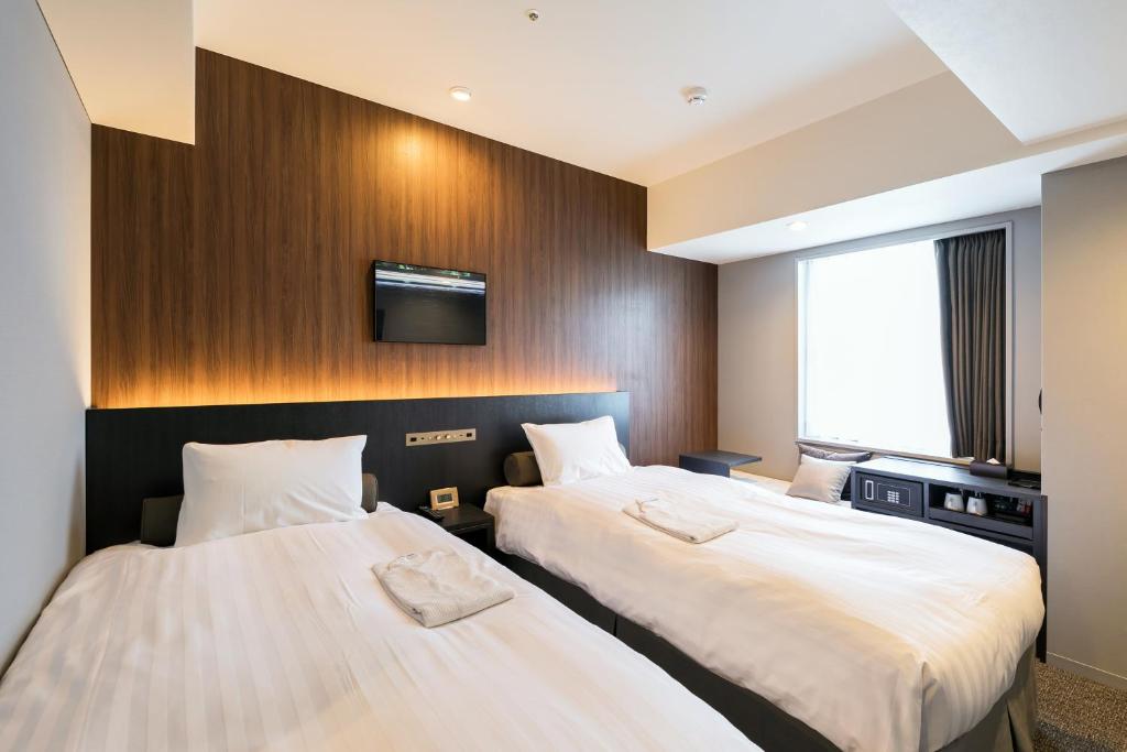 Postel nebo postele na pokoji v ubytování Ginza Capital Hotel Moegi