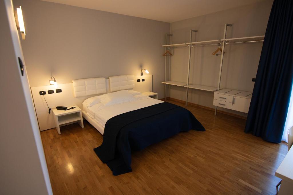 een slaapkamer met een groot bed en een houten vloer bij Master Hotel Reggio Emilia in Reggio Emilia