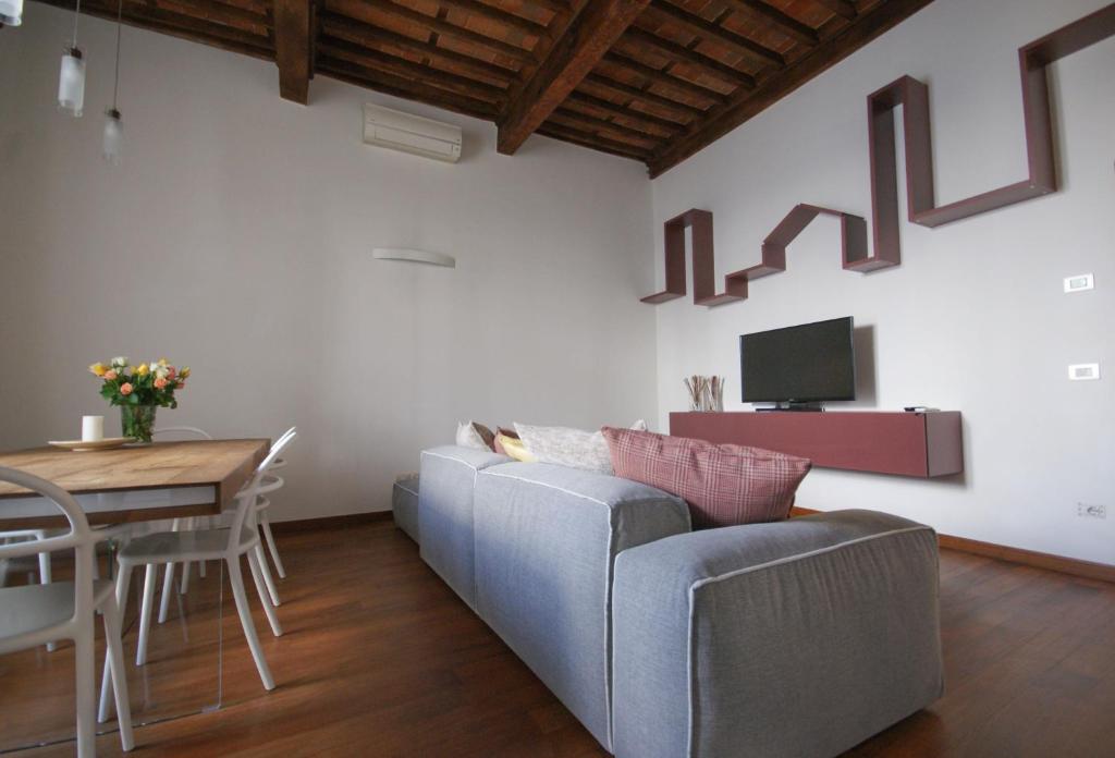 ein Wohnzimmer mit einem Sofa und einem Tisch in der Unterkunft Tabacchi Luxury apartment in Lucca historical center near toll Parking in Lucca