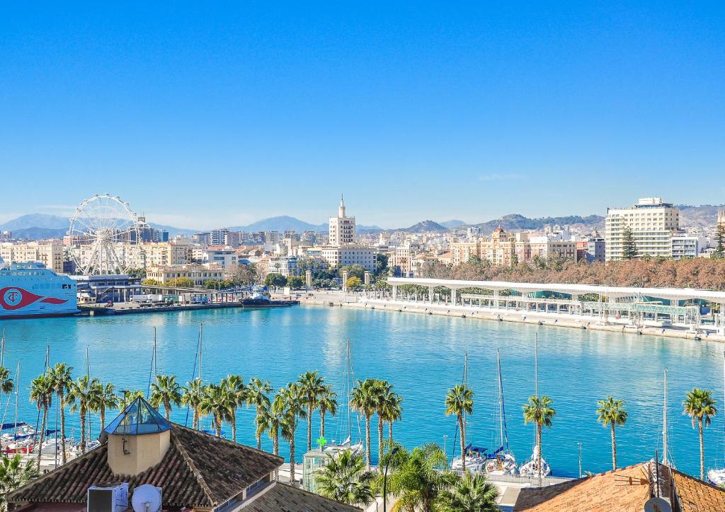 a view of a river with palm trees and a city at Malagueta Beach by Málaga Planners in Málaga