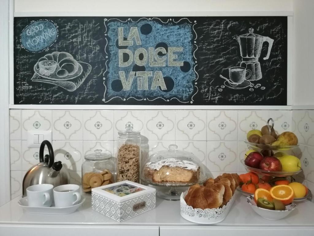 uma mesa com vários alimentos e uma placa na parede em B&B LA DOLCE VITA em Gragnano