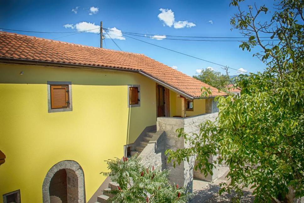 una casa amarilla con una escalera al lado en Holiday Home Veli Brgud, en Jurdani