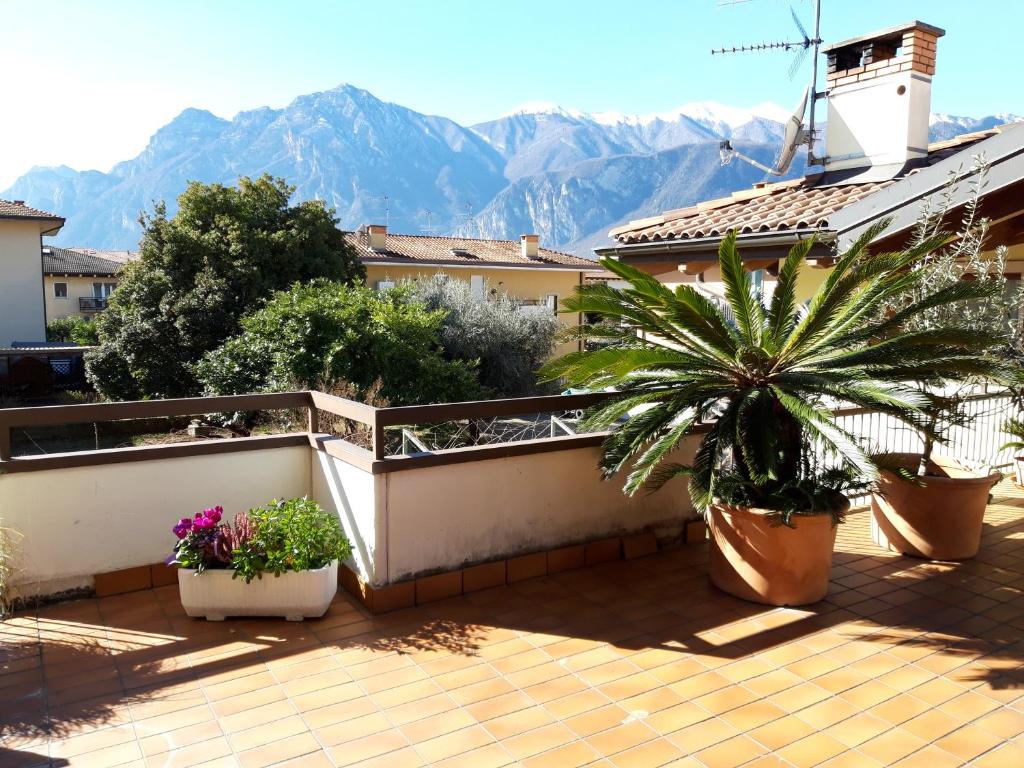 a balcony with potted plants and mountains in the background at Appartamento la Terrazza in Arco