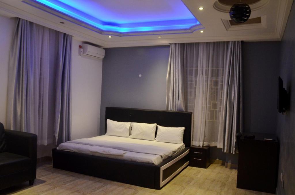 a bedroom with a bed with a blue light on the ceiling at House X in Abuja