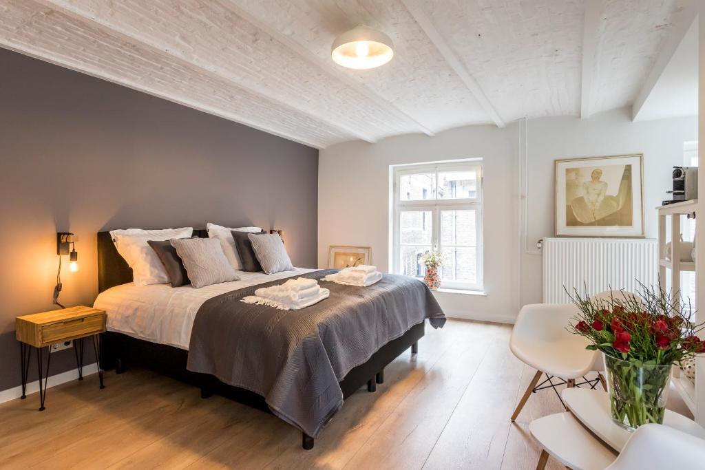 1 dormitorio con 1 cama grande y 1 mesa en B&B Gracht 62, en Maastricht
