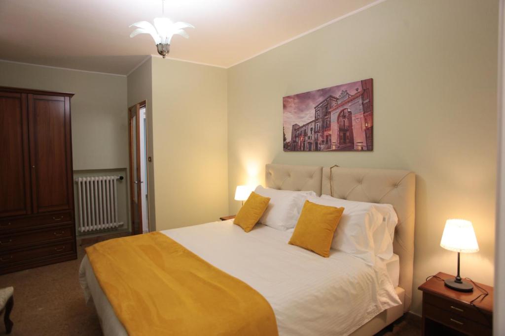 a bedroom with a large white bed with two yellow pillows at Relais del borgo in Guardiagrele