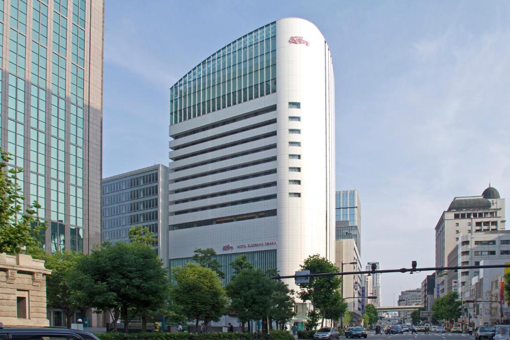 un edificio blanco alto en una ciudad con edificios en Hotel Elsereine Osaka, en Osaka