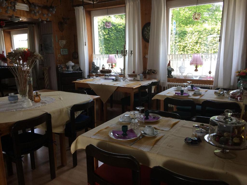 una sala da pranzo con tavoli, sedie e finestre di Beau-sejour a Francorchamps