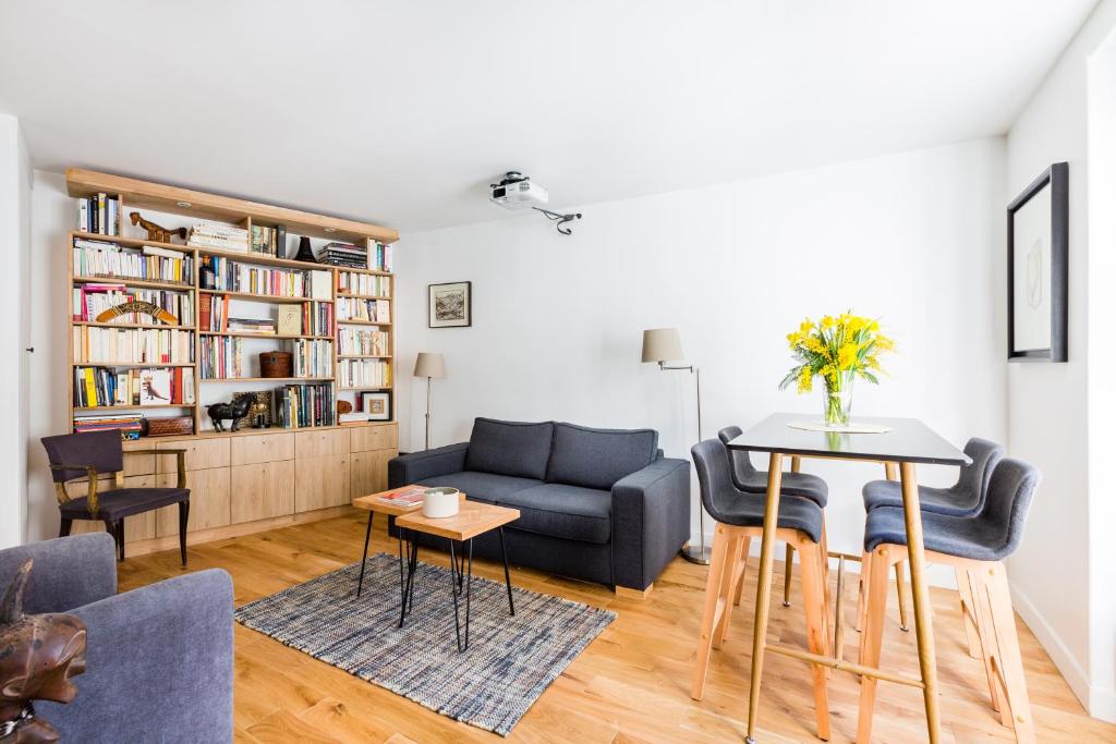 a living room with a couch and a table at Veeve - À la Mode Retreat by the Seine in Paris