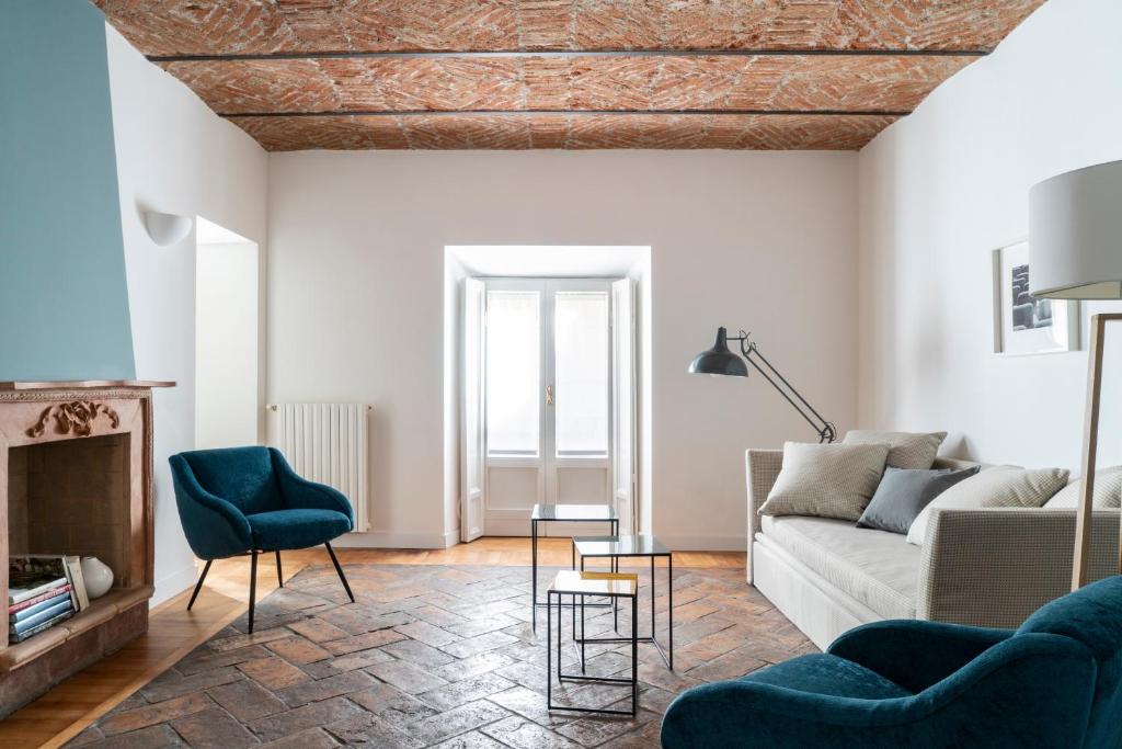 sala de estar con sofá y chimenea en Brera Apartments in San Fermo, en Milán