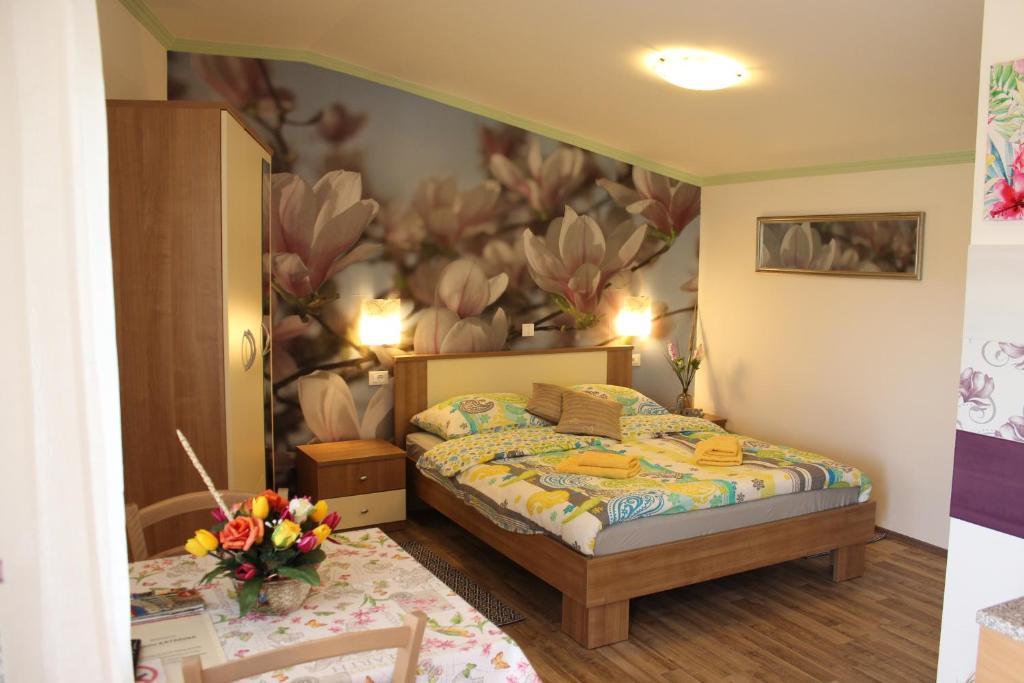 1 dormitorio con 1 cama con un mural de flores en la pared en Rooms Katarina, en Poreč