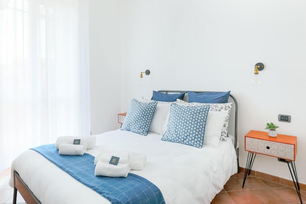a bedroom with a large bed with blue and white pillows at Vinylogy Apt in Rome