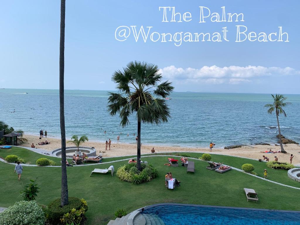 un balcón con vistas a la playa desde el complejo de playa cubierto de palmeras en Beach Front Condominium at The Palm Wongamat en Pattaya North