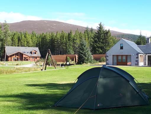 a tent sitting in the middle of a field at Badaguish forest lodges and camping pods in Aviemore