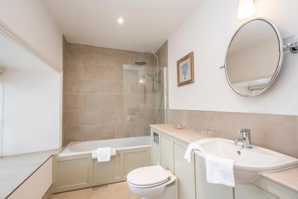 a bathroom with a sink and a toilet and a mirror at Heacham Manor Hotel in Hunstanton