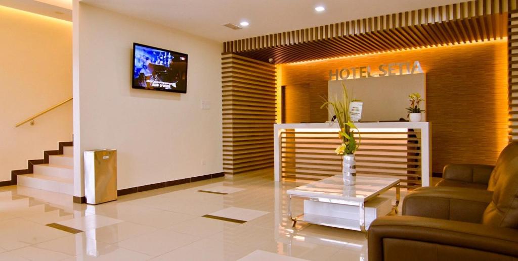 a lobby with a waiting room with a couch and a tv at Hotel Setia in Kluang