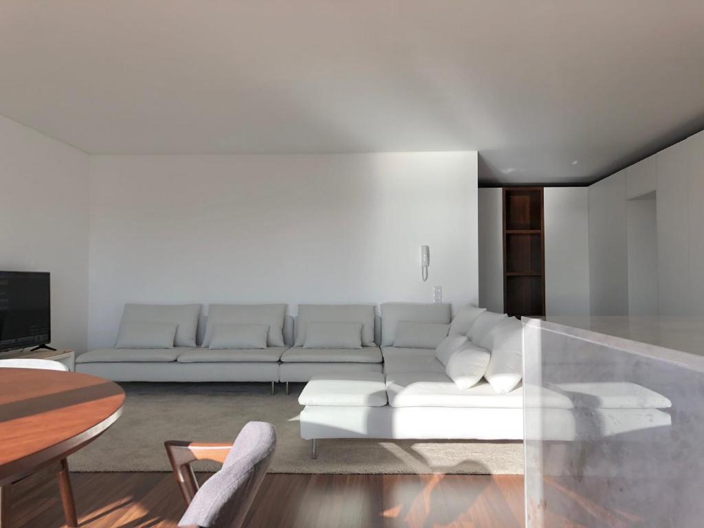 een woonkamer met een witte bank en een tafel bij VMO Apartment in Vila do Conde