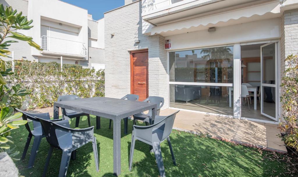 um pátio com uma mesa e cadeiras num quintal em Eulalia Apartments, TarracoHomes em Altafulla