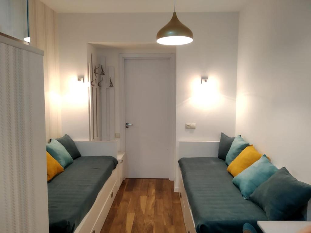 a living room with two green couches with colorful pillows at City Center Apartment 2 in Tbilisi City