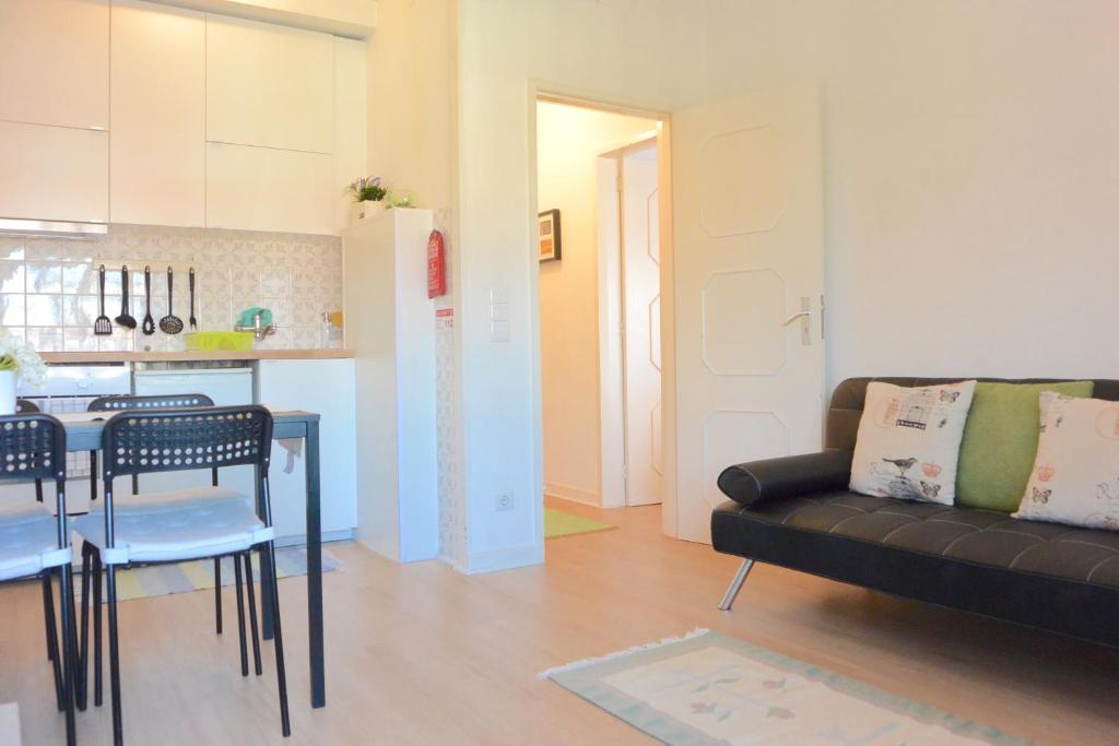 a living room with a black couch and a kitchen at Porto Fontainhas, by Flat in Porto in Porto