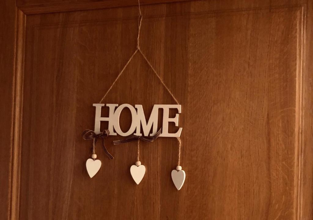 a home sign with hearts hanging on a door at Ani Apartments in Umag