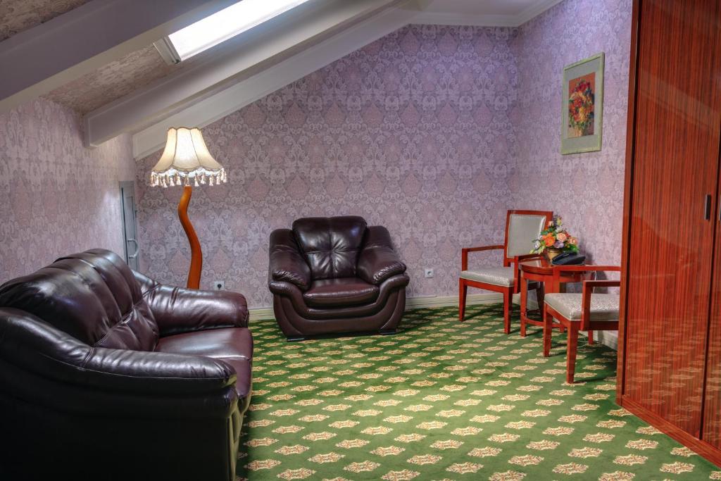 a living room with two leather chairs and a table at City Line Boutique Hotel in Tashkent