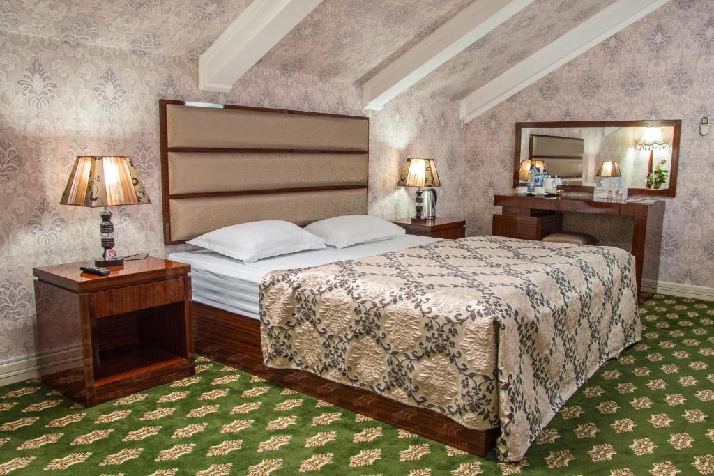 a bedroom with a large bed and a mirror at City Line Boutique Hotel in Tashkent