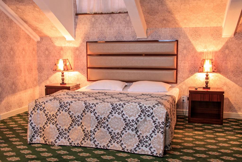 a bedroom with a bed with two night stands and two lamps at City Line Boutique Hotel in Tashkent