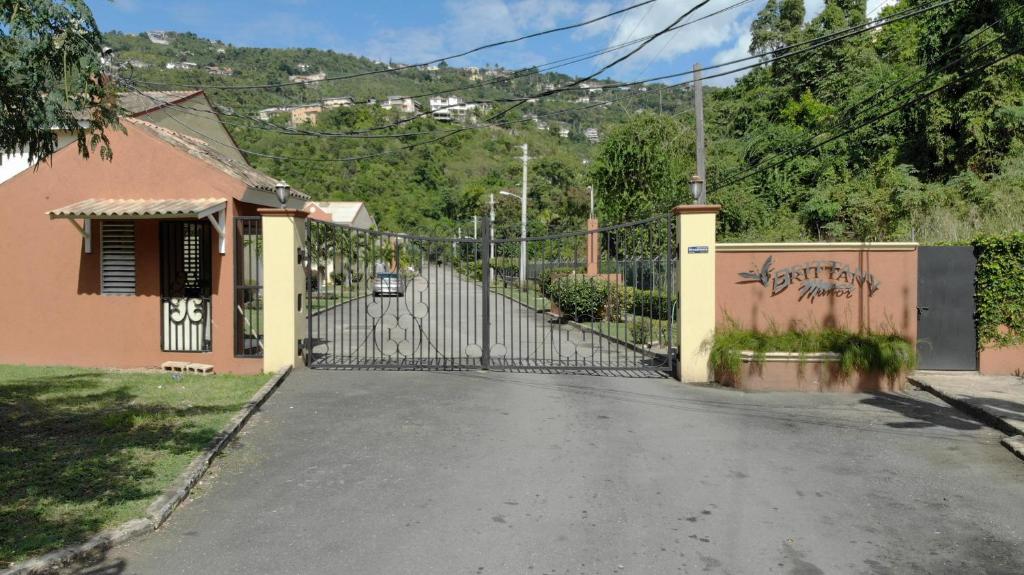 an empty street with a gate in front of a house at Brittany Manor Retreat in Kingston