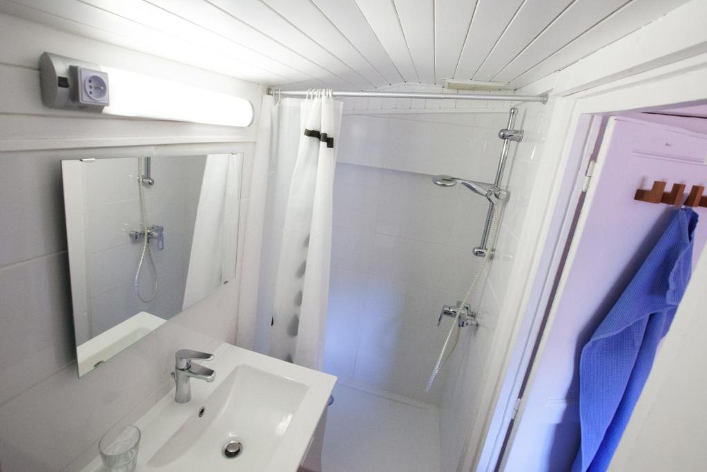 a white bathroom with a shower and a sink at Capitole - Studio d&#39;amoureux sur les toits in Toulouse