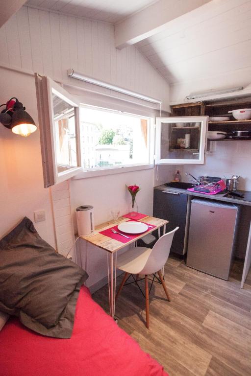 a small room with a table and a kitchen at Capitole - Studio d&#39;amoureux sur les toits in Toulouse