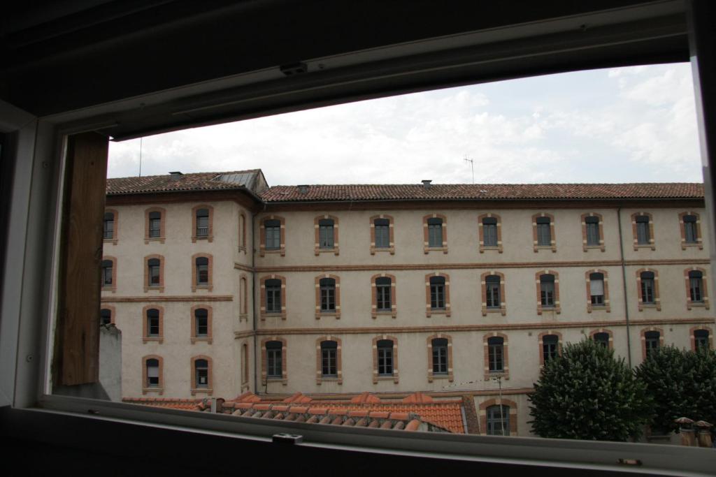 a view of a large building from a window at Capitole - Studio d&#39;amoureux sur les toits in Toulouse