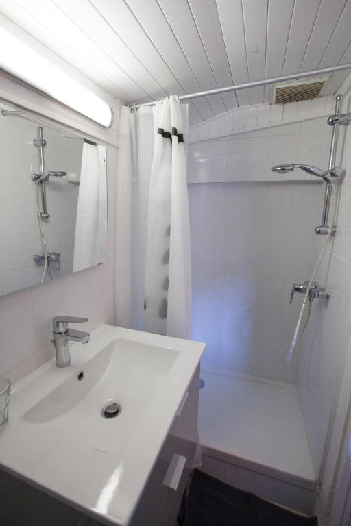 a white bathroom with a sink and a shower at Capitole - Studio d&#39;amoureux sur les toits in Toulouse