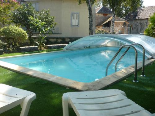 a swimming pool with a slide in a yard at Le Miramont in Orincles