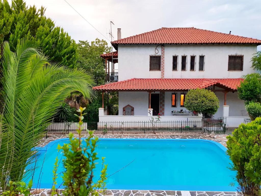 a house with a blue swimming pool in front of a house at Ancient Olympia Luxury Pool Villa Palace 4Bedroom in Olympia