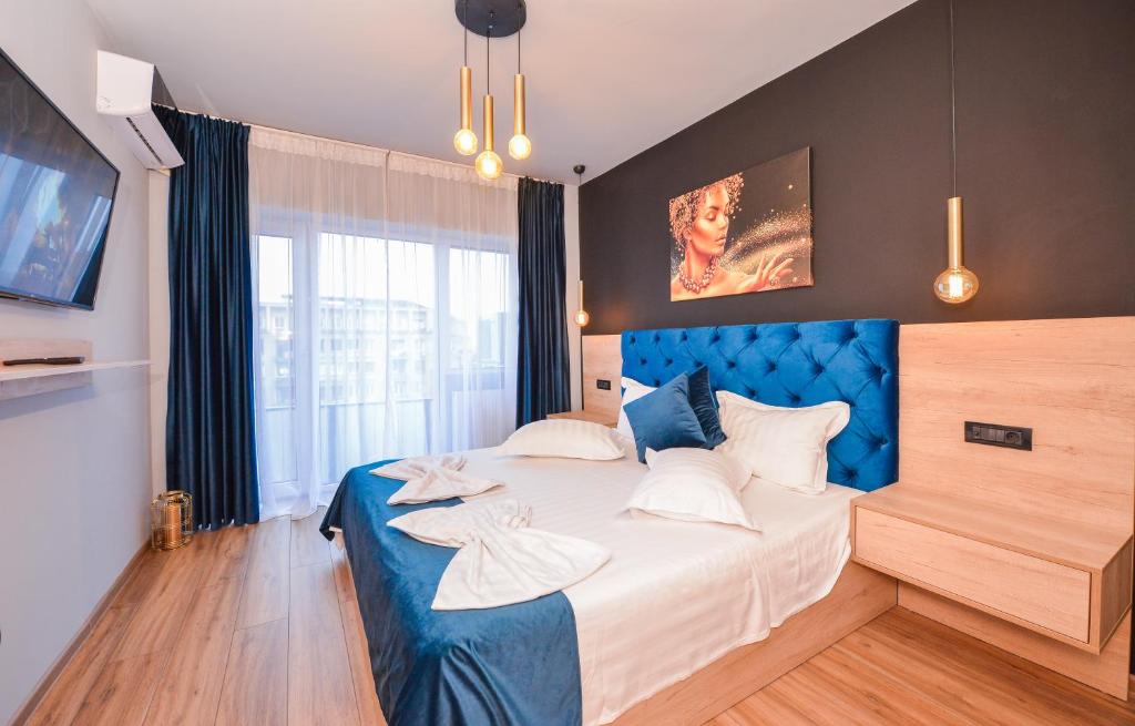 a bedroom with a large bed with a blue headboard at Grand Accommodation Apartments in Bucharest
