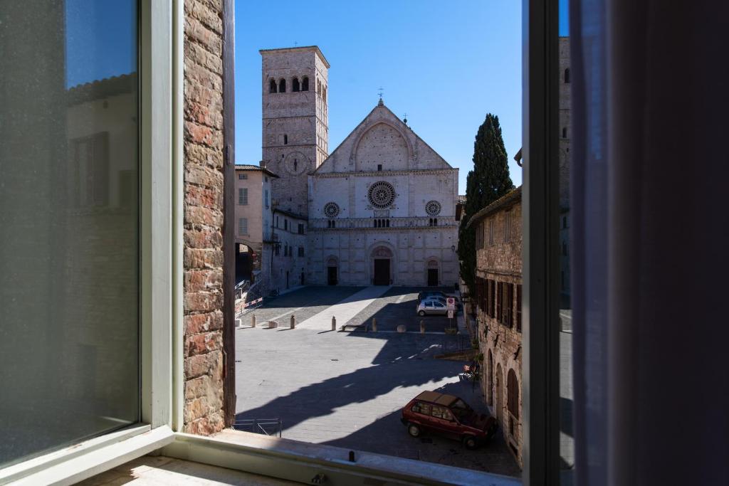 a view of a church from an open window at Arco del vento in Assisi