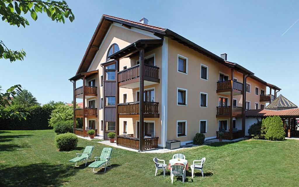 a large building with a table and chairs in the yard at Appartementhaus Safferstetten in Bad Füssing