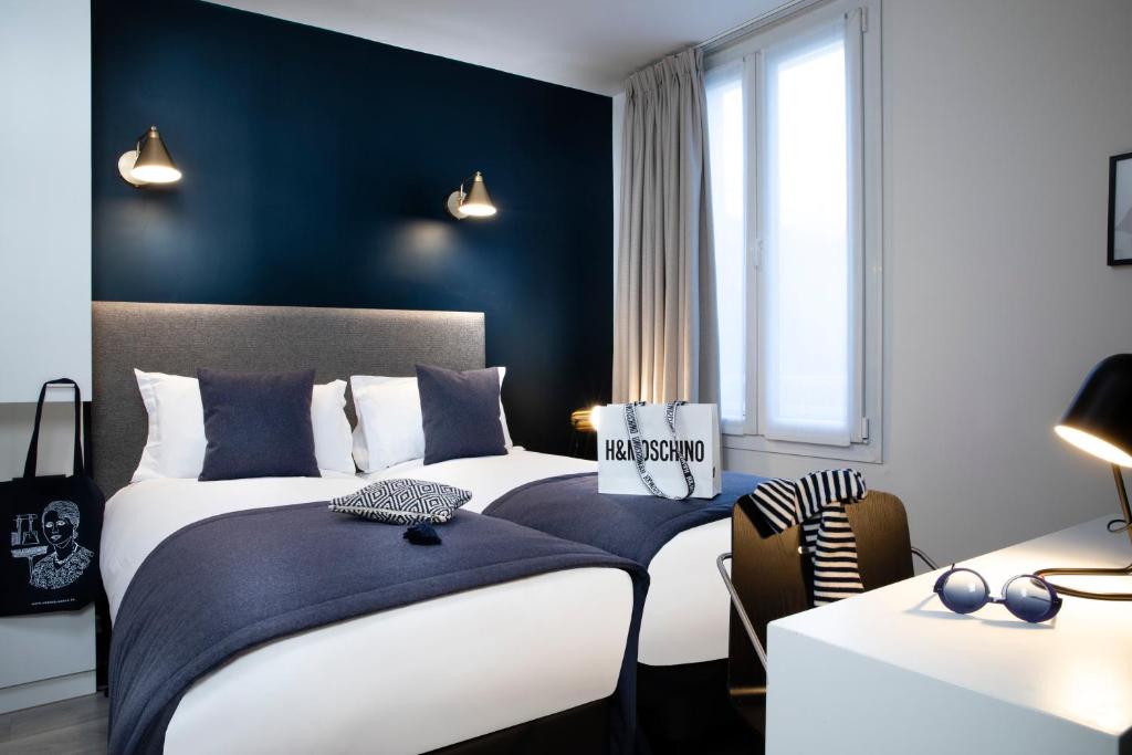 - une chambre avec 2 lits et un mur bleu dans l'établissement Hotel Brady - Gare de l'Est, à Paris