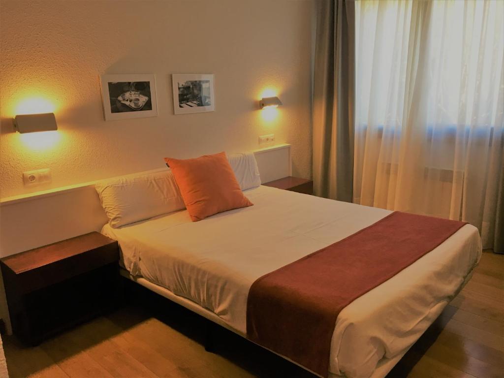 
a hotel room with a bed and two lamps at Hotel Elorrio in Elorrio

