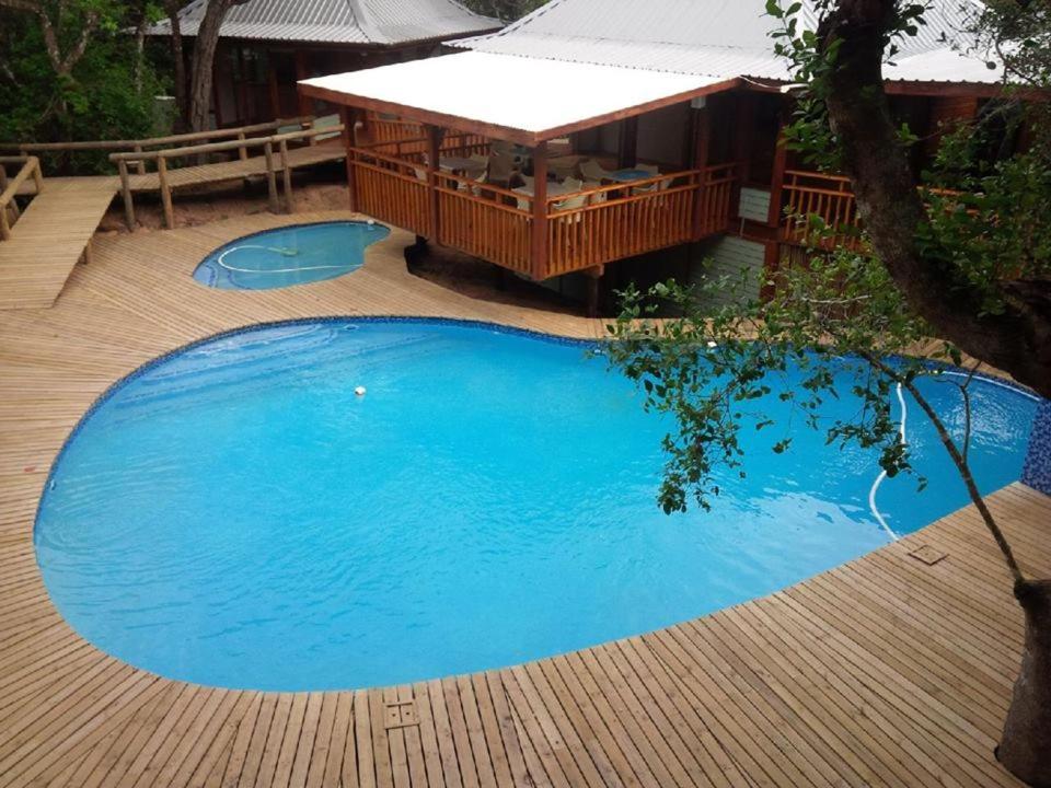 una gran piscina azul en una terraza de madera en Golden Beach Village, en Ponta do Ouro
