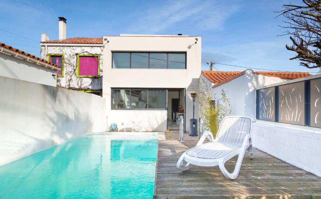 ラ・トランシュ・シュル・メールにあるMaison piscine centre ville La Tranche-sur-Merの白い家(スイミングプール、椅子付)